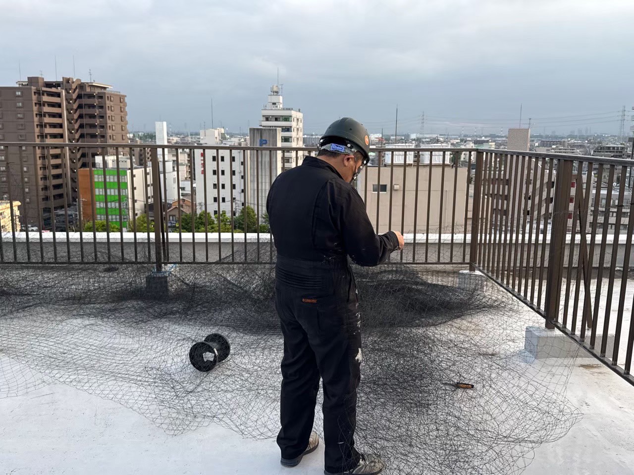 屋上でのネット準備作業：ネットを広げてサイズ確認・結束作業を行う